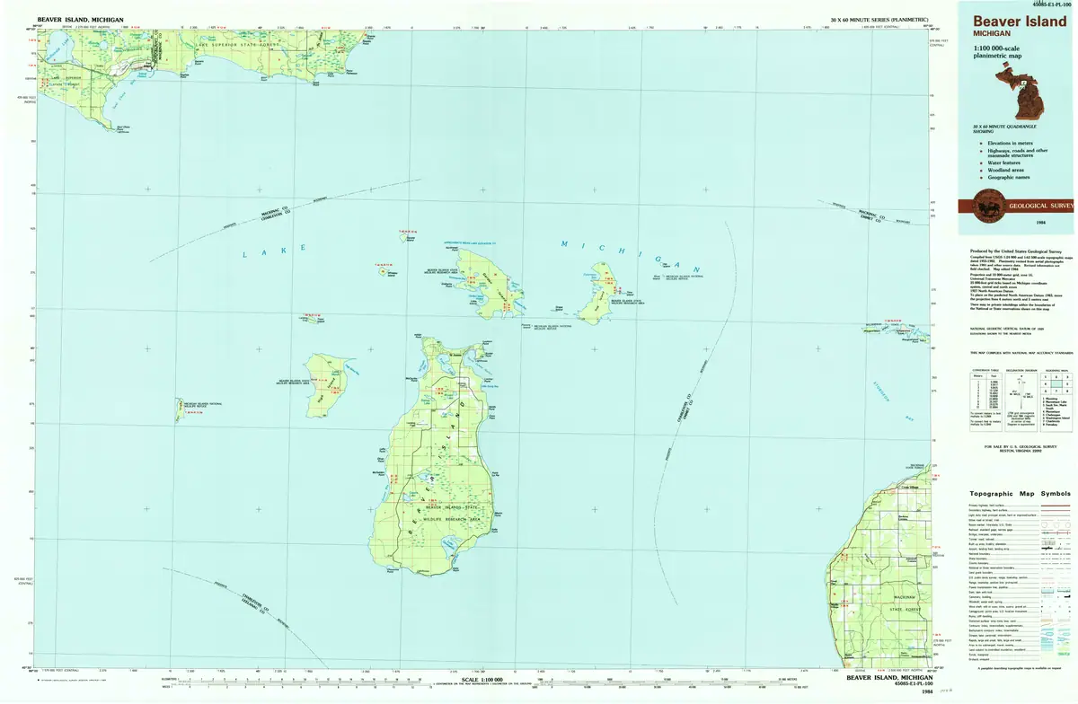 Colored topographic map showing several land areas, waterways, grid lines, roads, and a map-symbols legend.