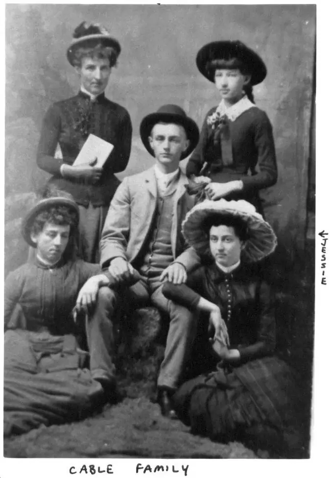 A formal black-and-white portrait shows five people arranged around a seated man in a suit and hat.
