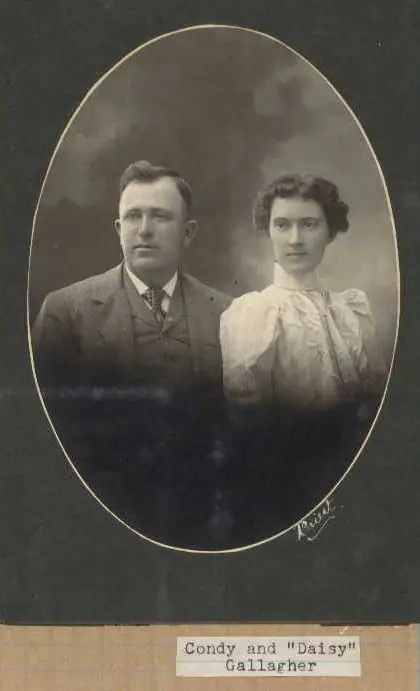 Sepia studio portrait of a formally dressed man and woman inside an oval frame.