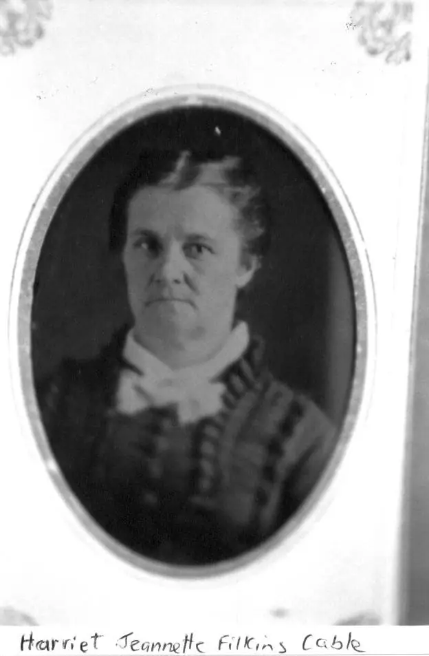 Black-and-white oval portrait of a woman in a dark dress with a light high collar.