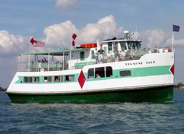 Green-and-white passenger ferry named DIAMOND JACK traveling across choppy water beneath a cloudy sky.