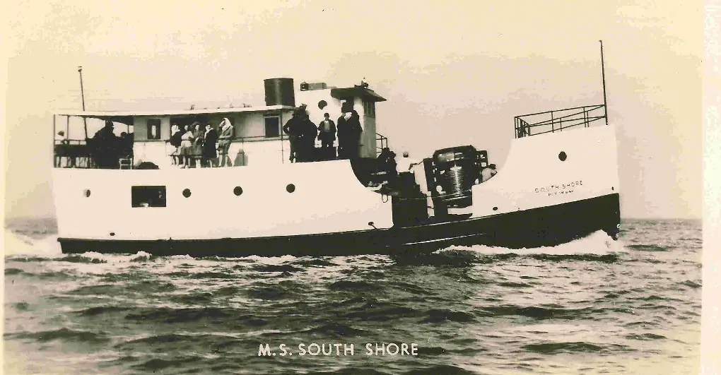 A white passenger ferry with people on deck travels across rippled water.
