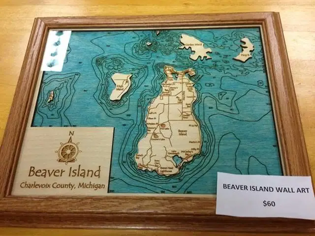 Framed wooden map artwork with blue water, tan landforms, a compass rose, and a $60 wall-art sign.