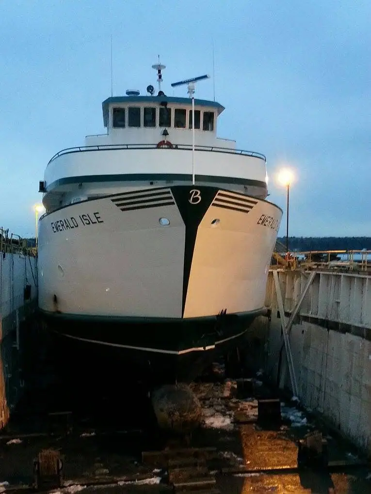 White ferry viewed head-on in a dry dock at twilight, with snow or ice on the ground.