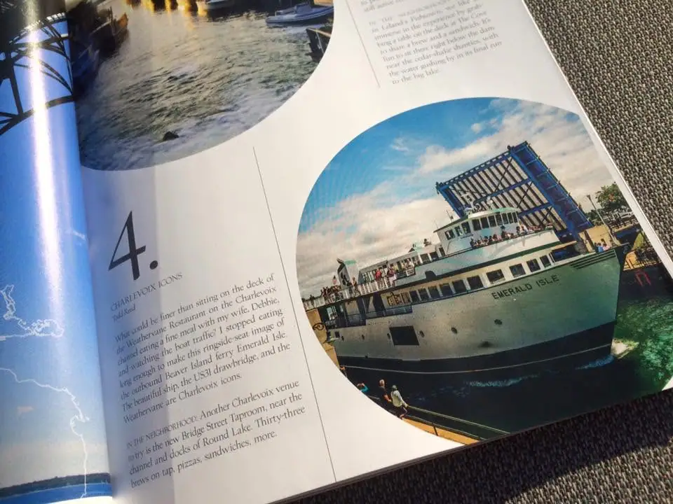 Open magazine spread showing a ferry beneath a raised drawbridge, with printed text and the vessel name visible.