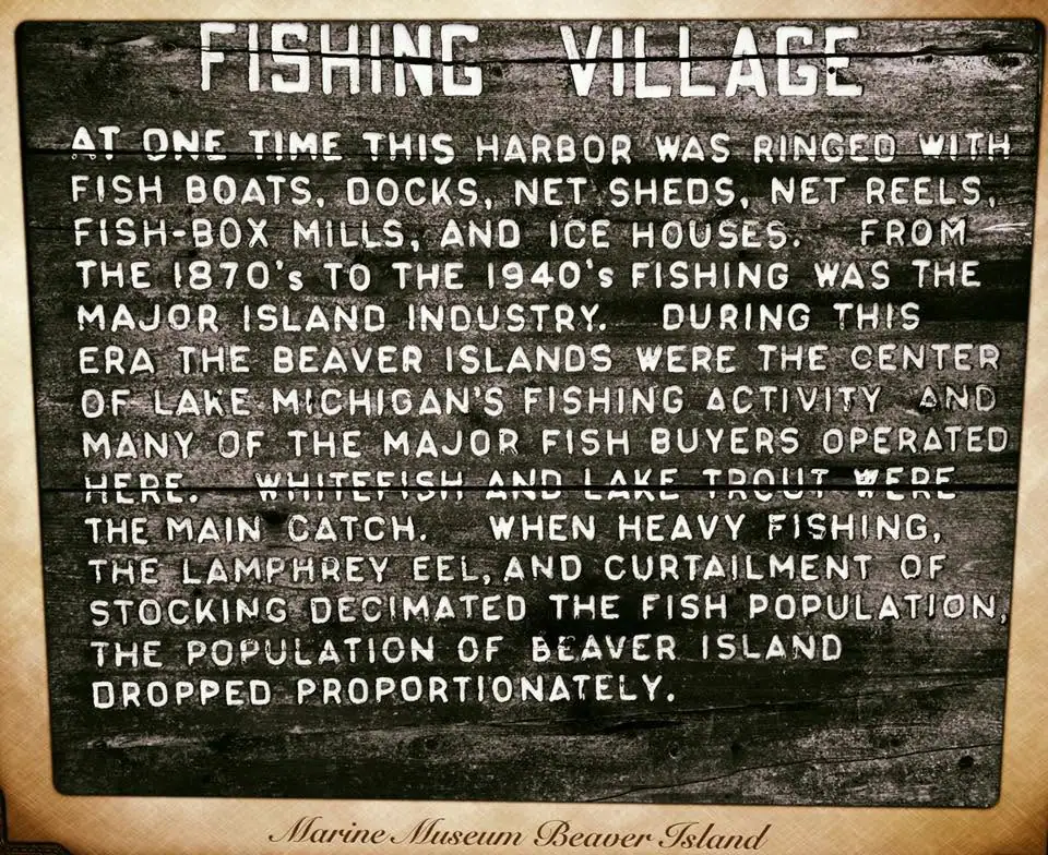 Close-up photograph of a historical sign about a former fishing industry and harbor.