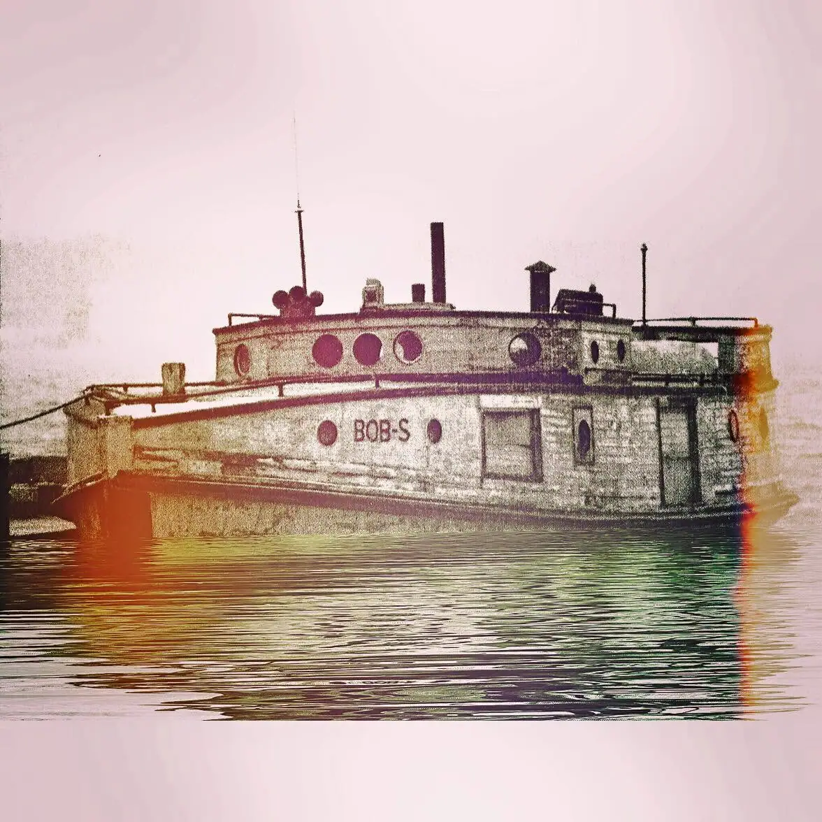 A white tugboat marked “BOB-S” sits on rippling water beneath a pale sky.