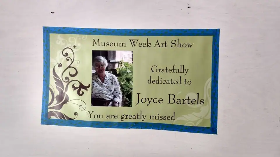 A decorated memorial poster with an inset portrait of an elderly woman and a dedication message.