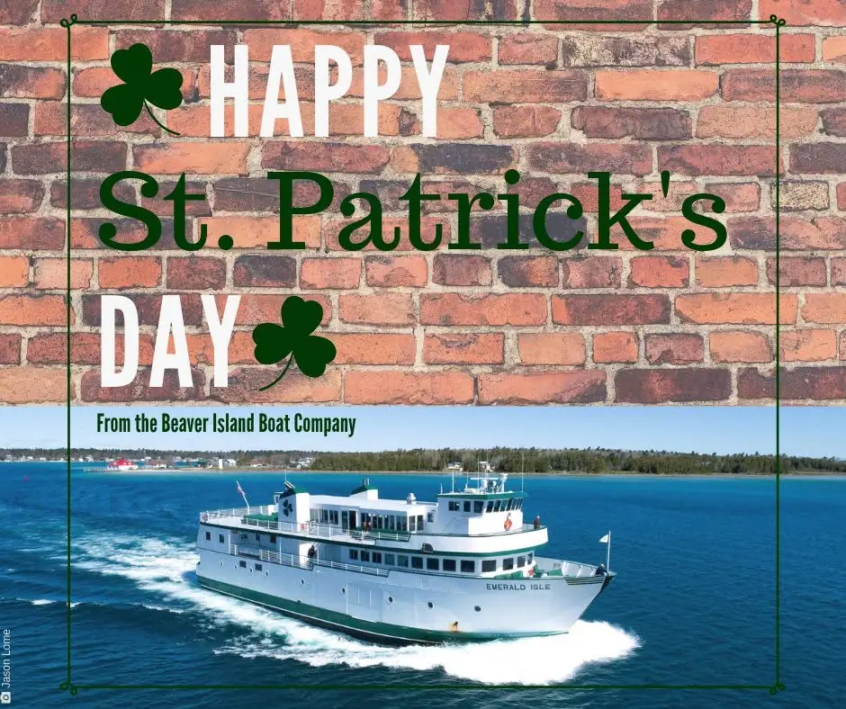 St. Patrick’s Day greeting graphic with shamrocks and a white ferry traveling across blue water.