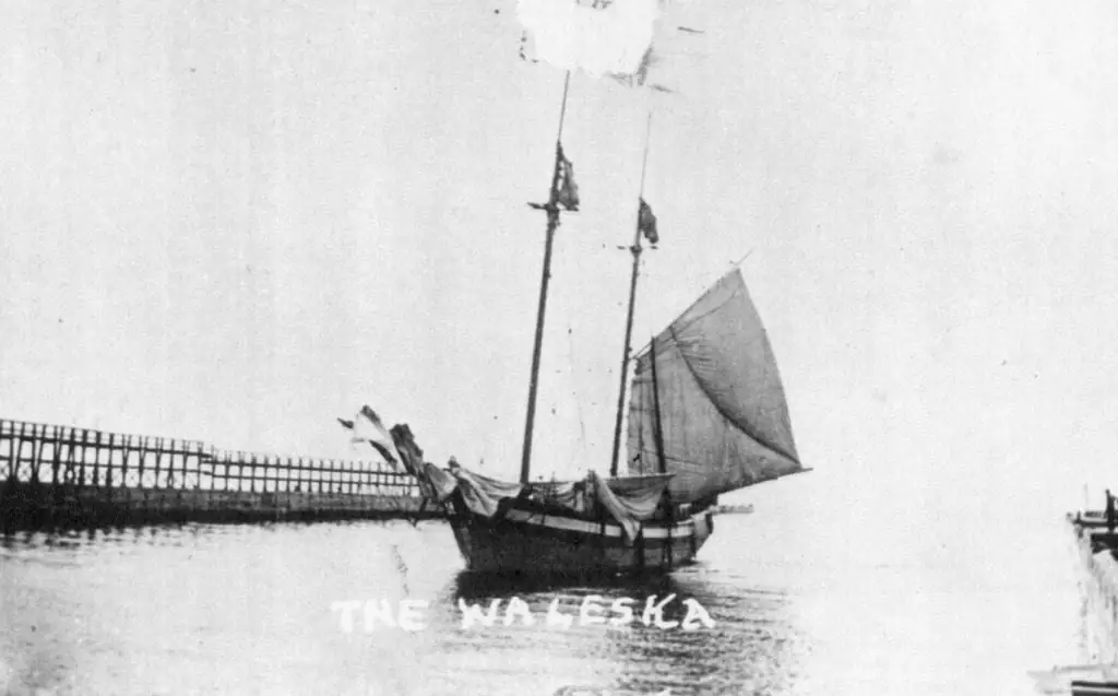 A two-masted sailing vessel passes beside a long wooden pier, with “THE WALESKA” printed across the lower image.
