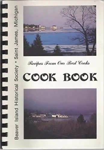 Spiral-bound cookbook cover with two landscape photographs and the title “Recipes From Our Best Cooks Cook Book.”