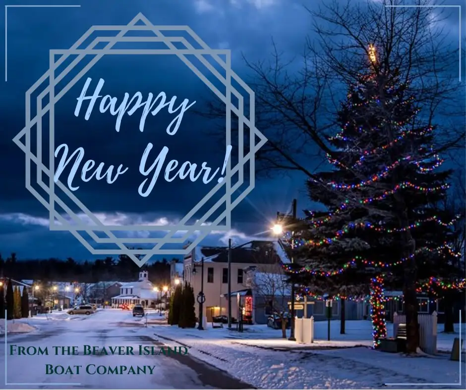 Snowy street at dusk with a brightly decorated evergreen and a Happy New Year greeting.