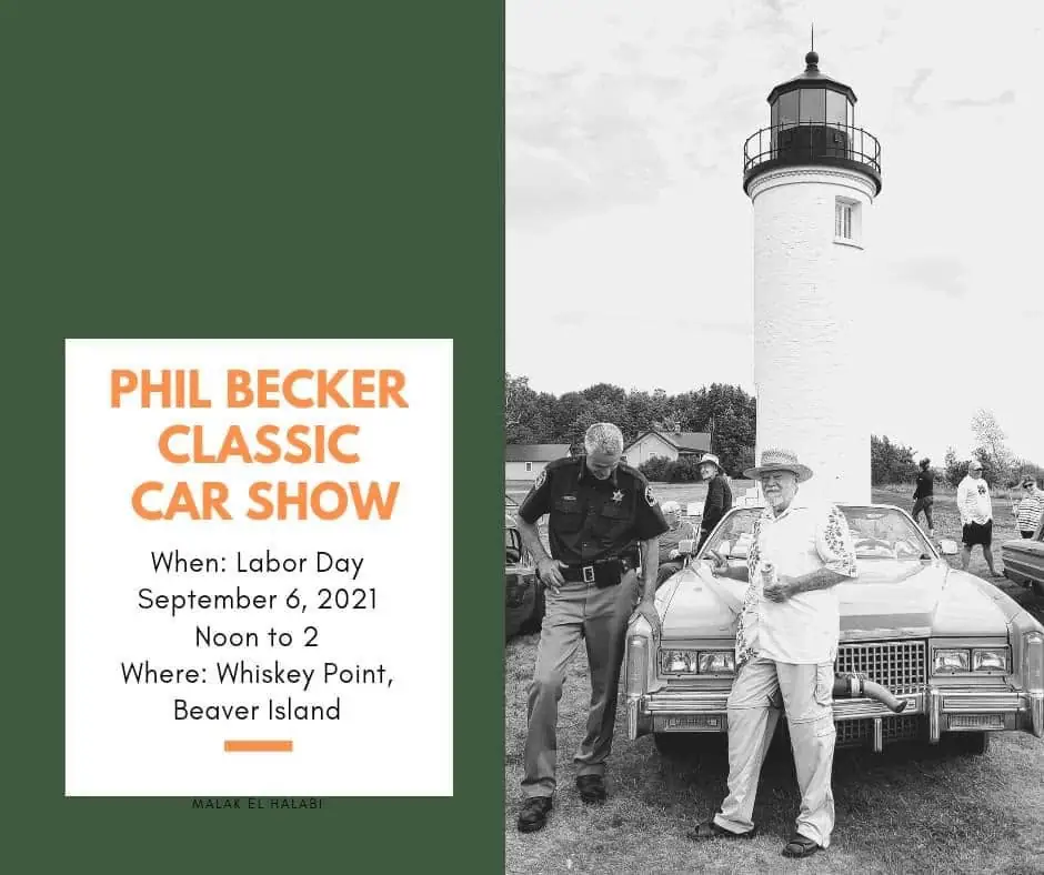 A classic car, a uniformed person, and another man stand before a lighthouse beside an event poster.