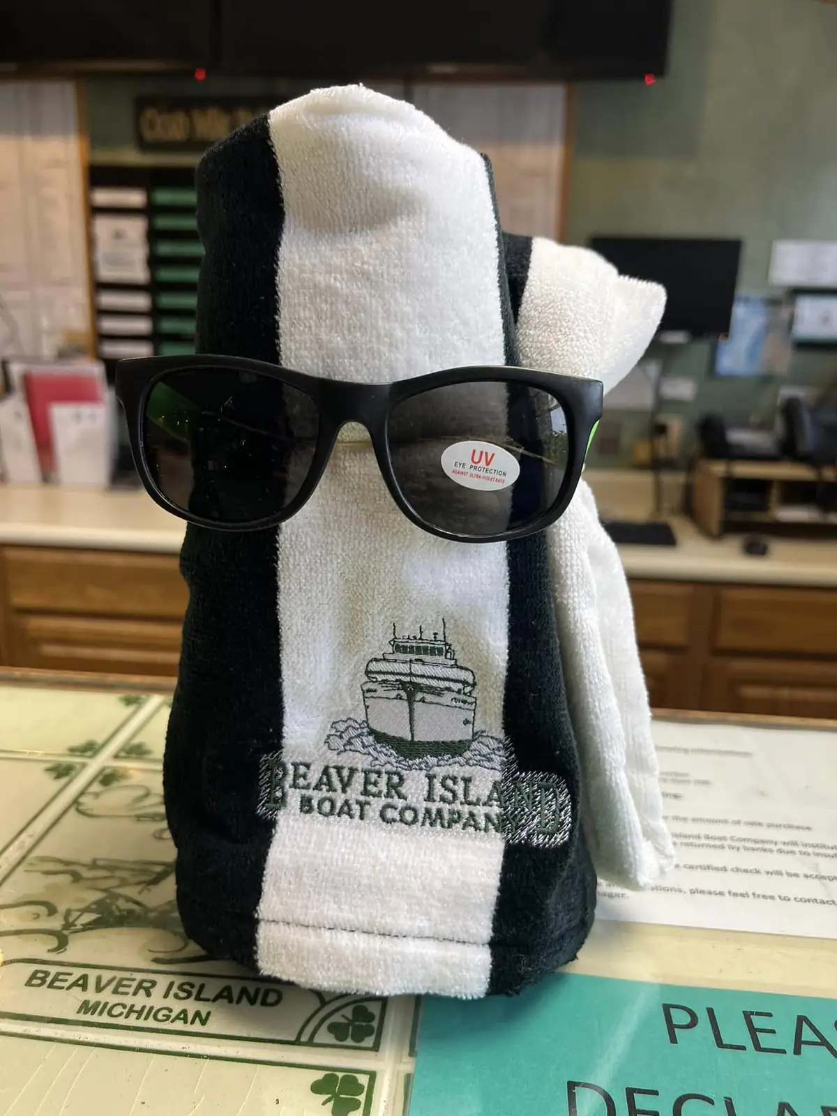 A striped fabric display figure wears sunglasses on a counter.
