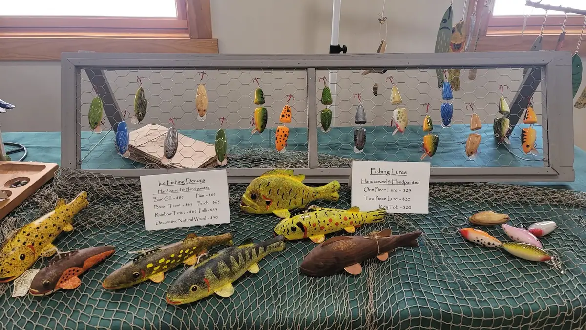 Display of hand-painted fish decoys and colorful fishing lures.