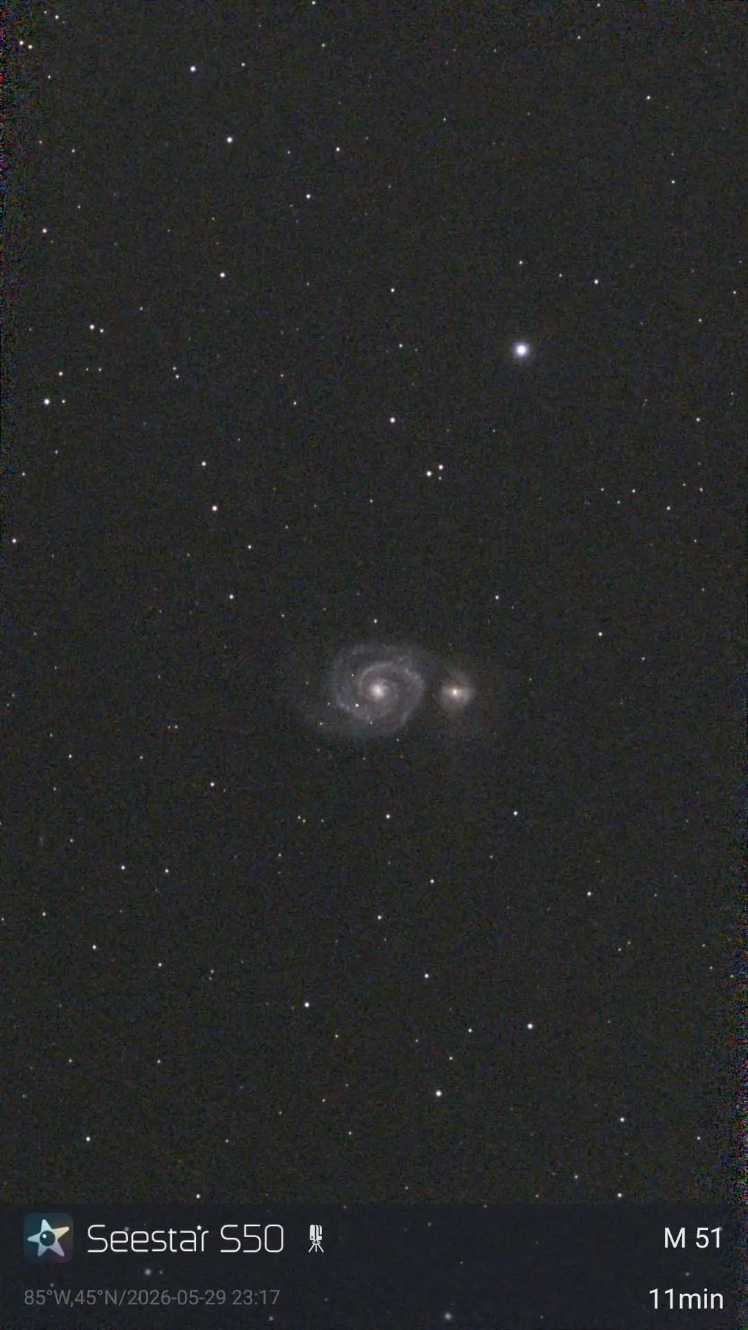Night-sky photograph showing a paired spiral galaxy and many stars.