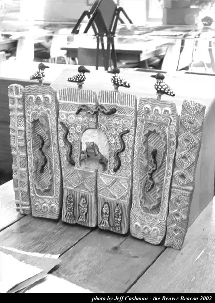 Black-and-white photograph of an ornate upright paper sculpture with four bird figures on top.