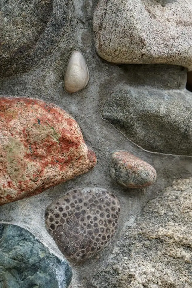 Close-up of assorted rounded stones with varied colors, textures, and a honeycomb-like pattern.