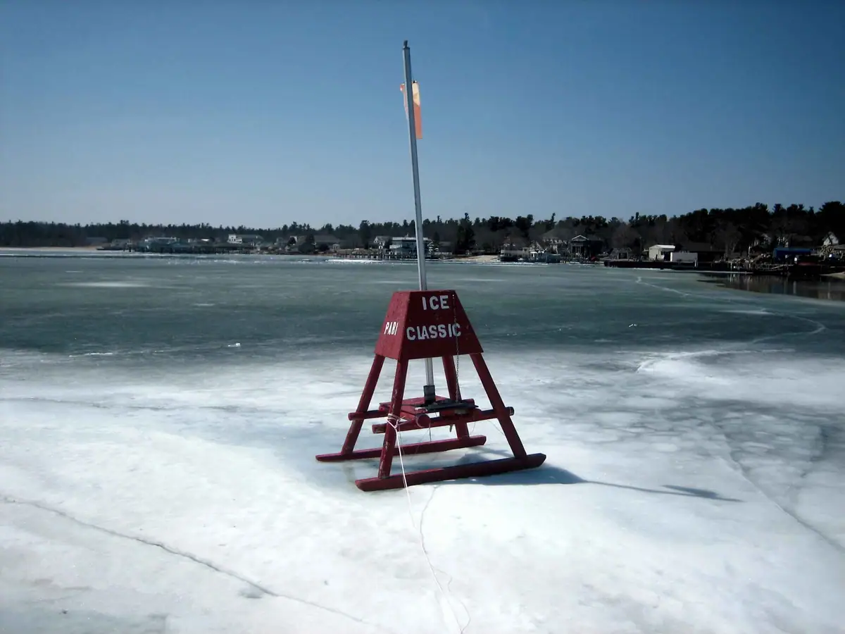 A red wooden ice marker labeled “PABI ICE CLASSIC” stands on runners over a frozen expanse.