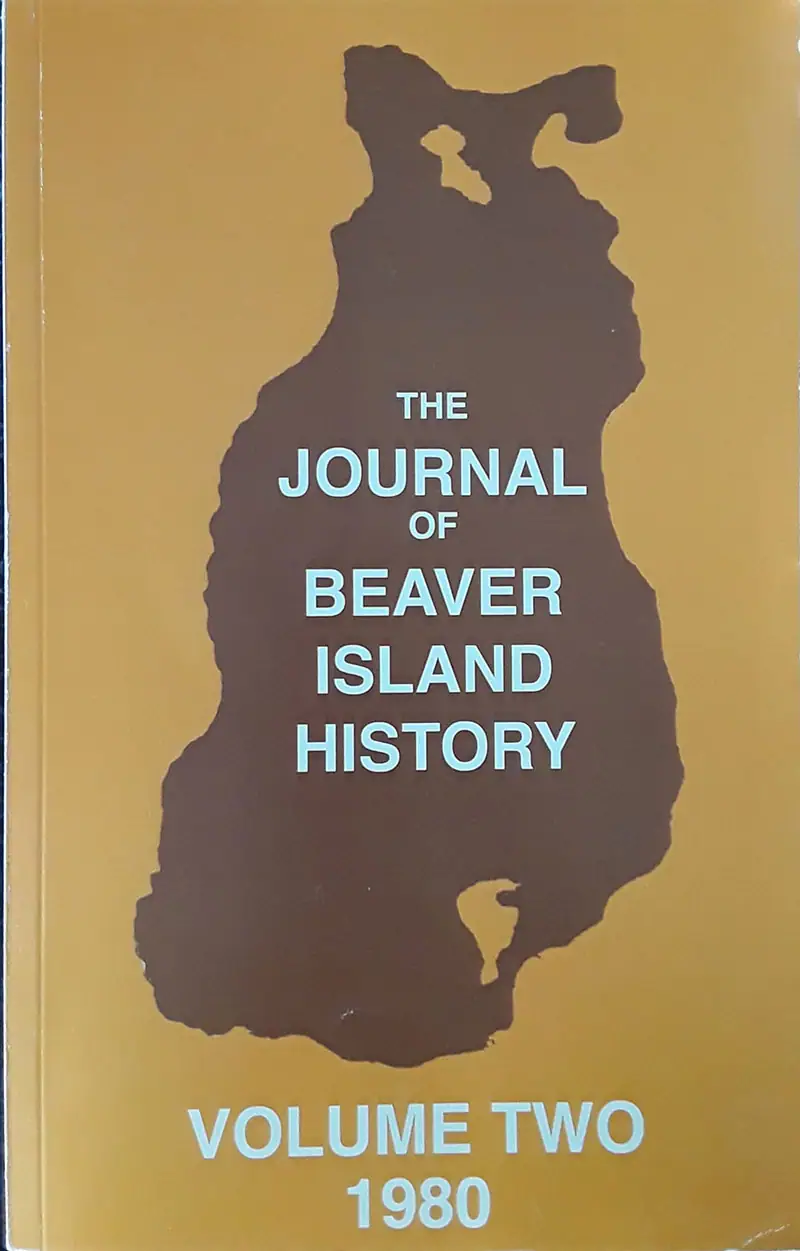 Photograph of a gold-colored journal cover with a dark silhouette and pale blue title lettering.
