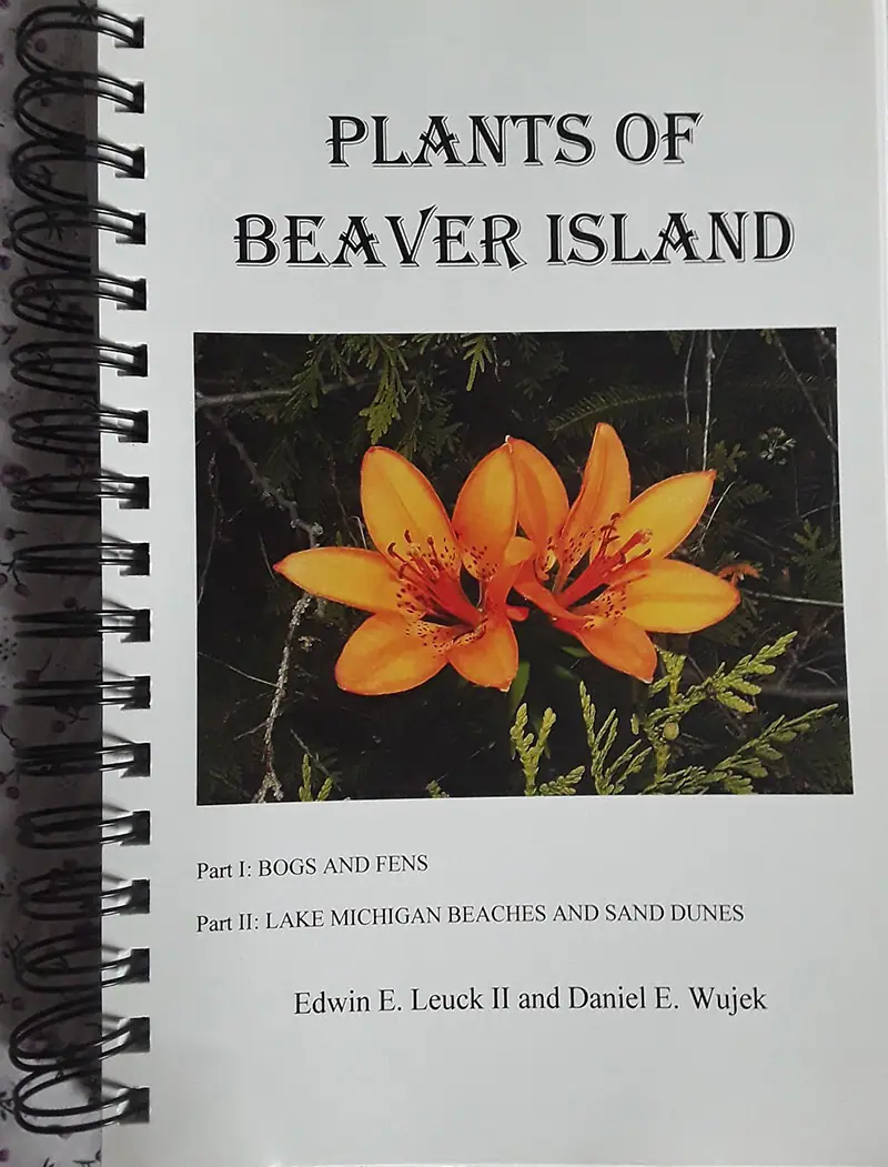 Photograph of a spiral-bound booklet cover featuring two orange flowers among green foliage.