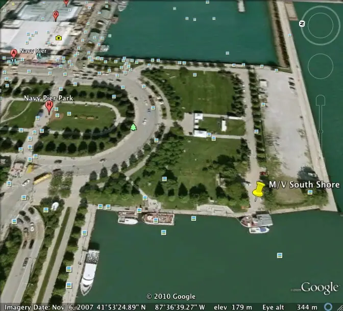 Satellite map showing a waterfront park, pier, roads, lawns, docks, and a vessel marker.